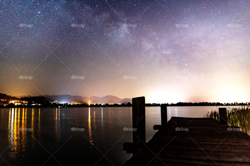 The milkywqy above a lake with much lightpollution