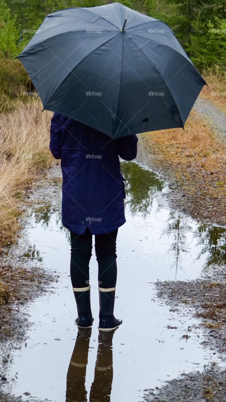 Rear view of person standing in puddle