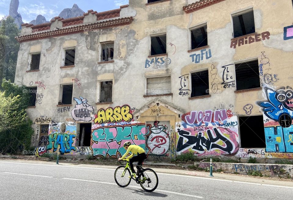 Cycling up the road by an abandoned house 