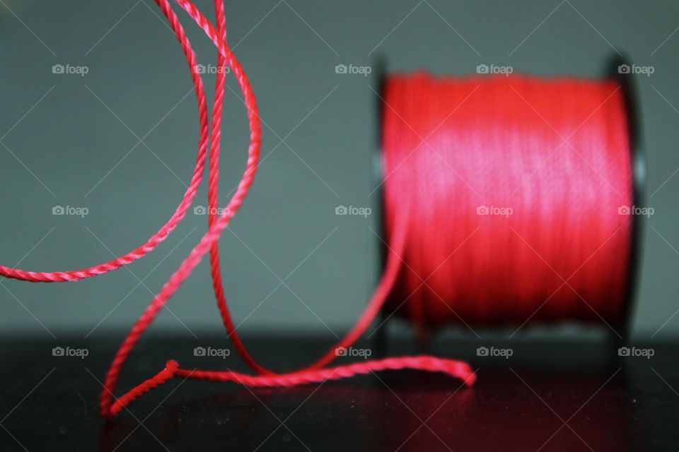 Close-up of a red mason's cord coiled on a spool