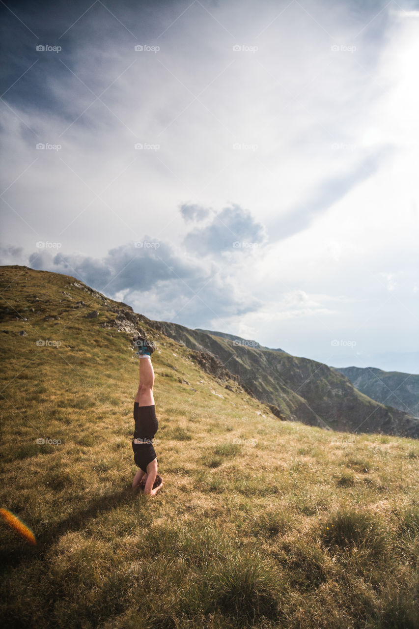 woman doing a handstand în the mountains
