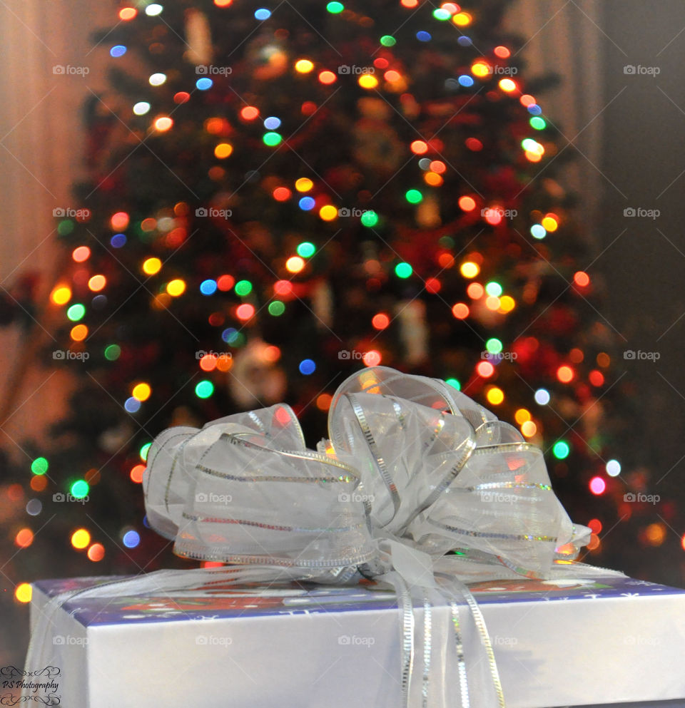 Close-up of gifts with christmas tree in background