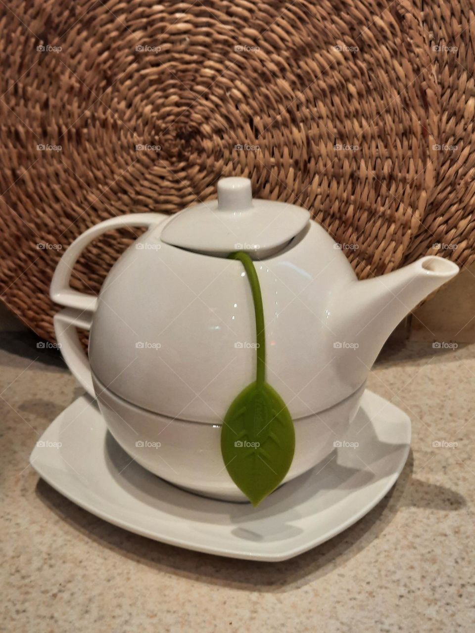 white tea pot with green leaf