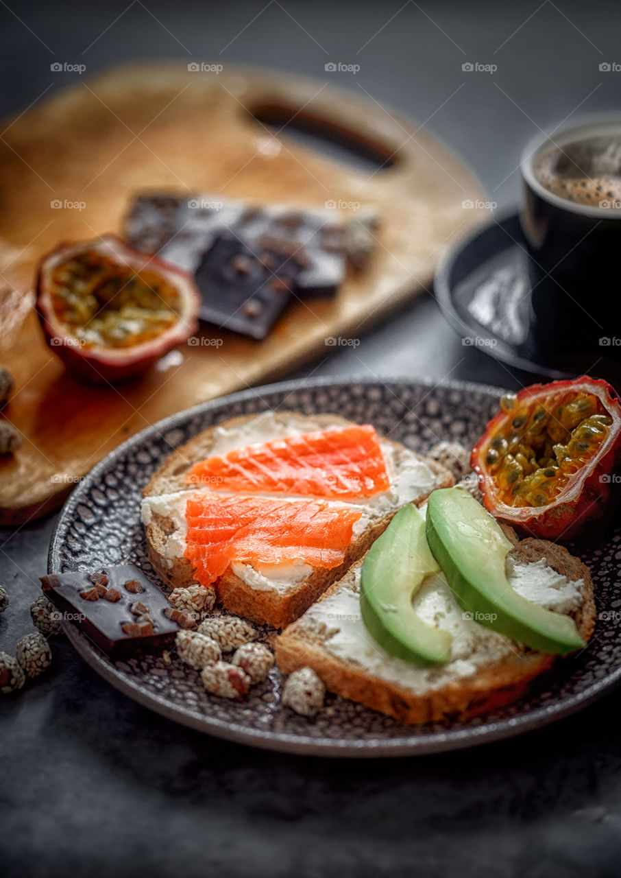 Dietary sandwiches of grain toasts with cream cheese, fish, avocado and passion fruit 