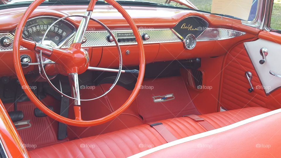 the interior of a vintage red Bel Air vehicle at a car show