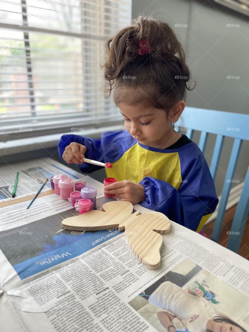 Little girl paints a wooden butterfly, painting pink butterflies, painting with toddlers, painting pink butterflies with children