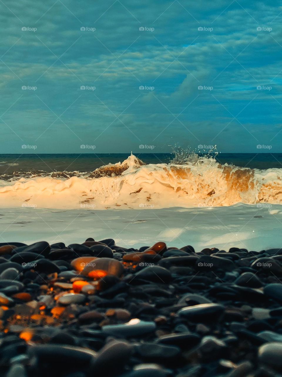 A sea wave on the background of sunset