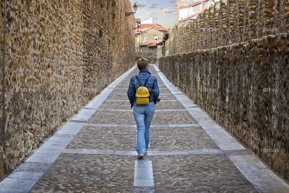 Woman walks through the medieval wall in Leon, Spain