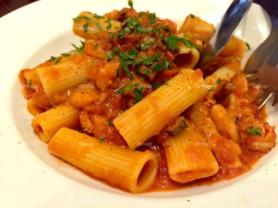 Close-up of pasta with serving tongs