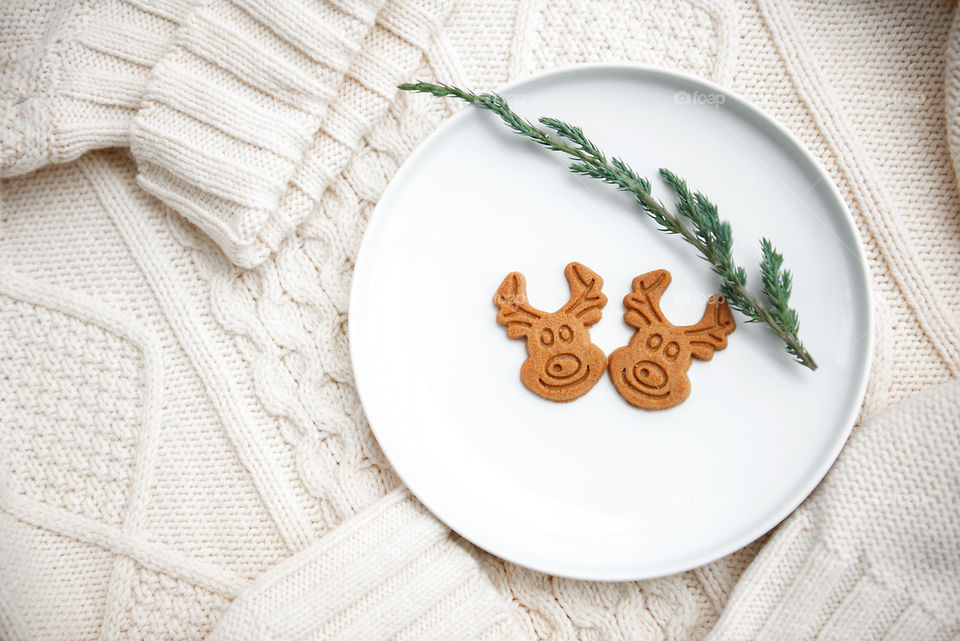 Christmas holiday flat lay with two gingerbread on a cozy knitted sweater