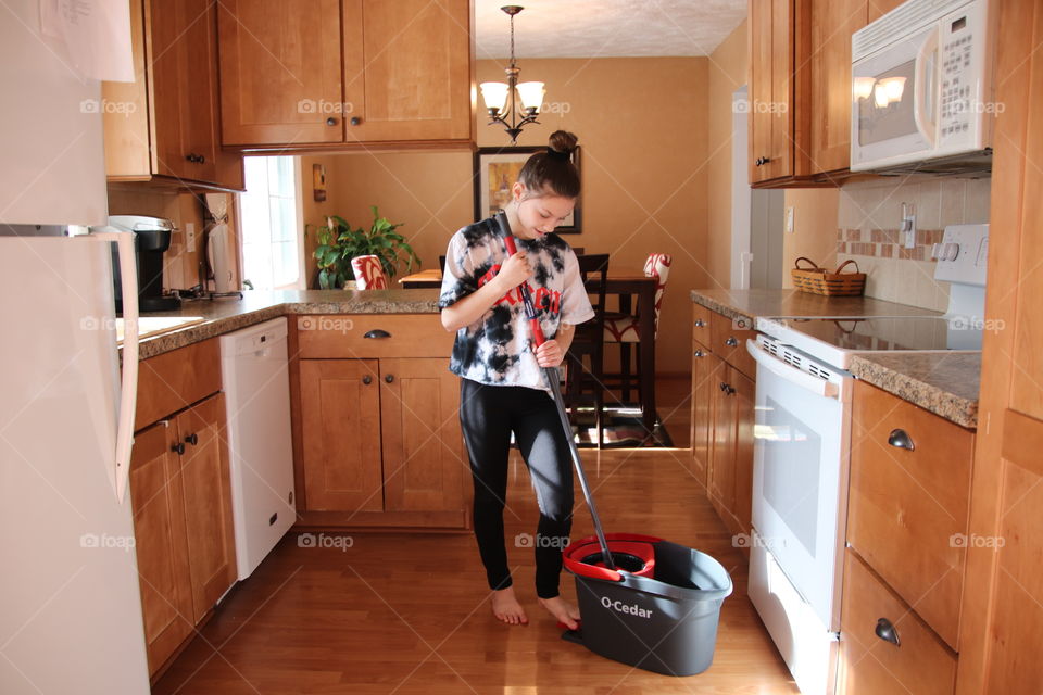 Girl using O-Cedar mop and bucket 