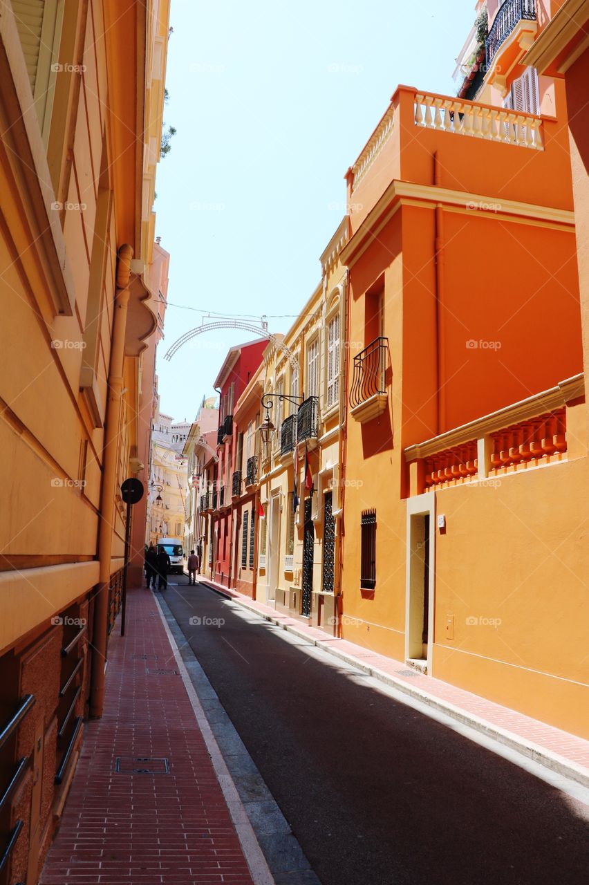 Colourful building in both site of a narrow street in old part of a French town 