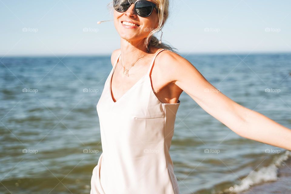 Young woman with beautiful jewellery necklace on sea background 