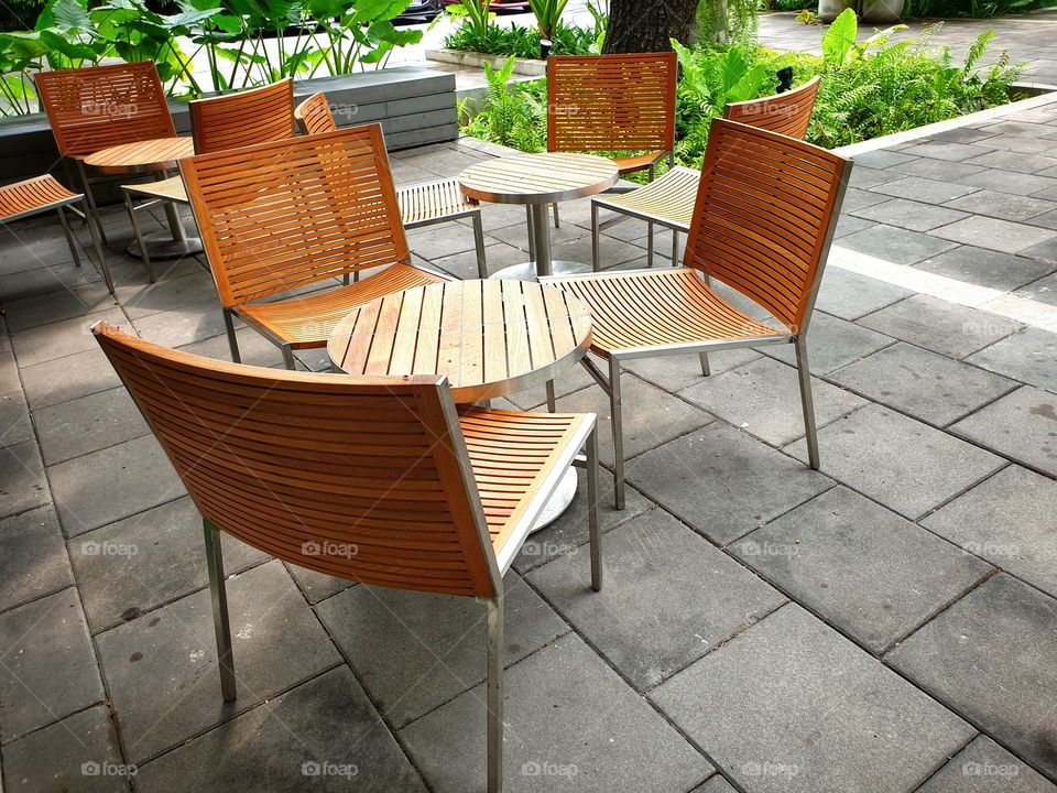 A charming set of matching tables and chairs, made from stainless steel frame and light wood at the patio. Very modern, contemporary design.