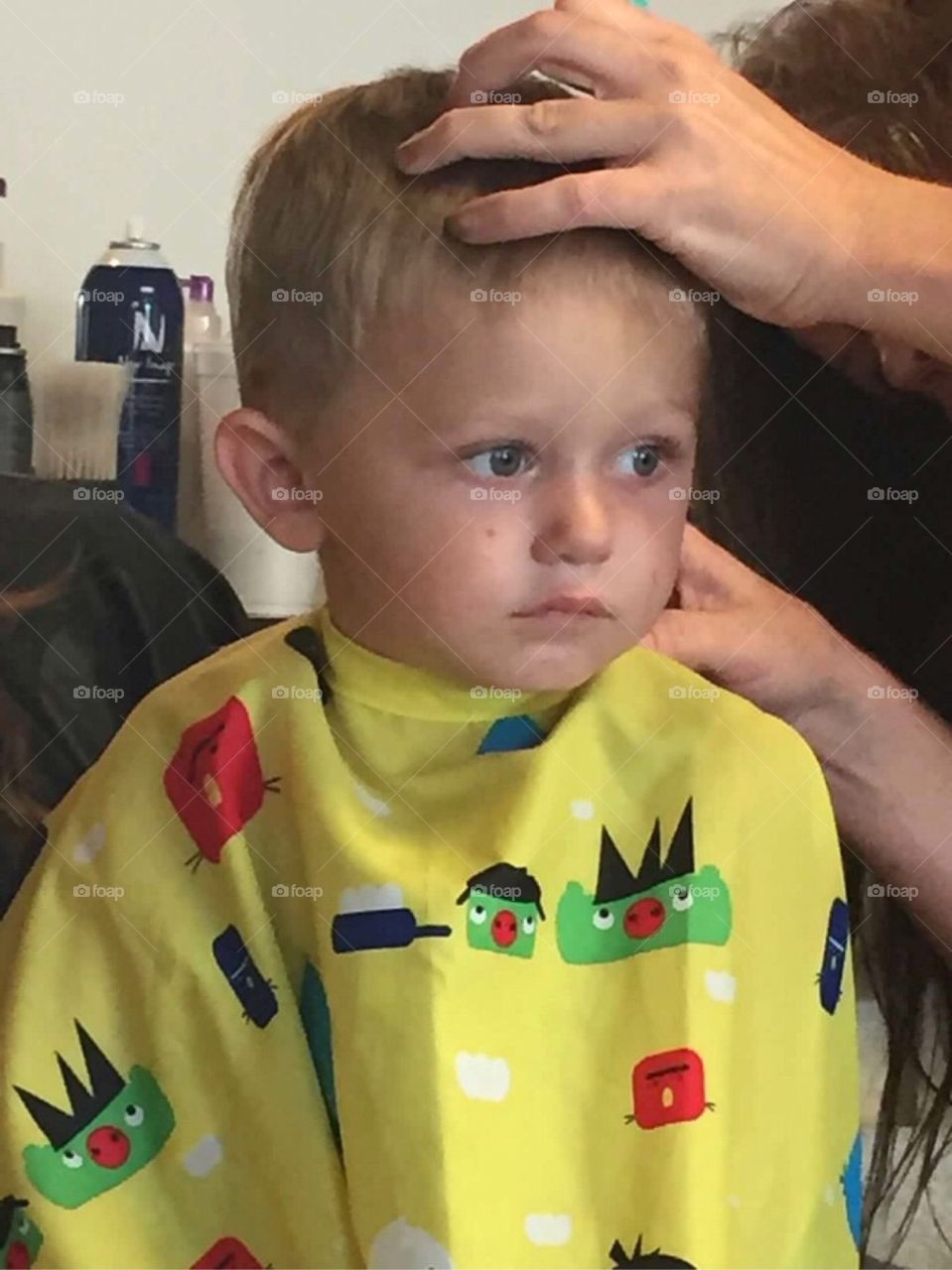 Young boy getting a hair cut at barbershop