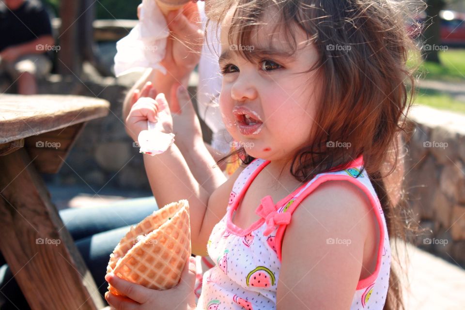 Little girl eating ice-cream cone