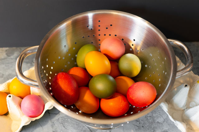 colorful eggs for easter in a sieve