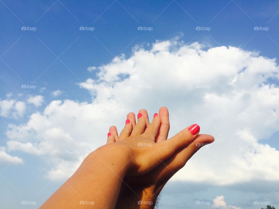 Her hand against his hand towards the sky