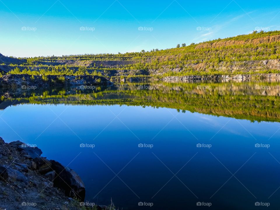 Reflections in a water mirror. Pervomaysky quarry, Zavitinskoye lithium deposit, Shilkinsky district, Zabaykalsky krai, Siberia, Russia.