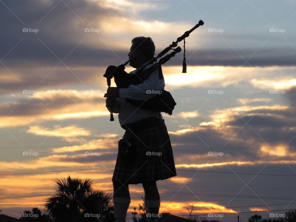 Bagpiper playing at sunset 