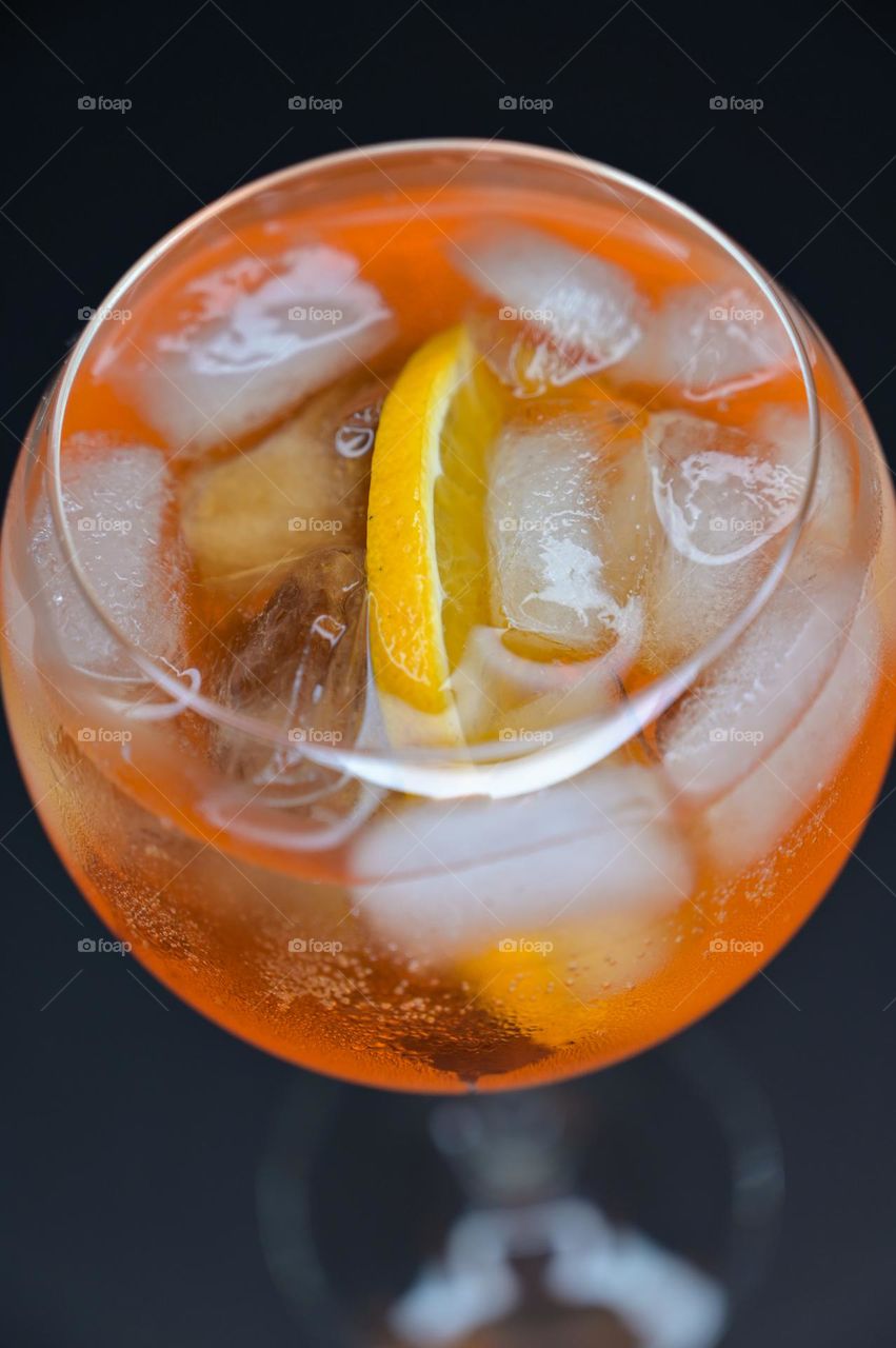 Orange cocktail with ice close up in a round glass