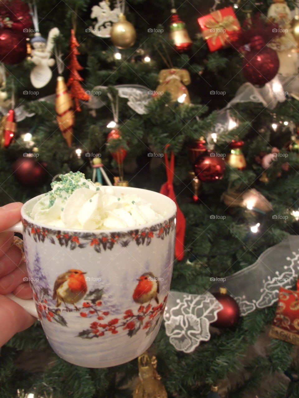 Christmas mug filled with hot chocolate in front of the Christmas tree