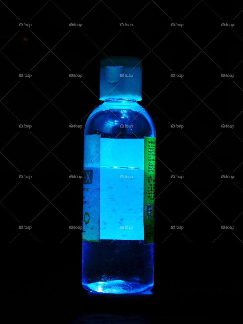 Blue Coloured lighting effect on sanitizer bottle having black background