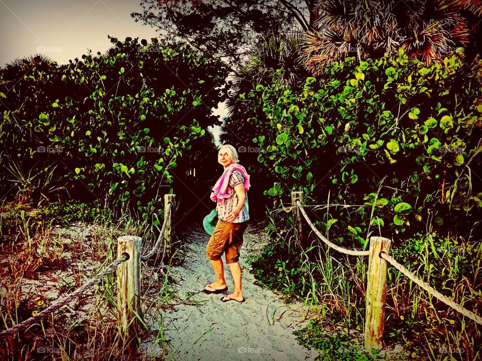 Lady on the beach. Lady on a beach trail through the seagrapes.