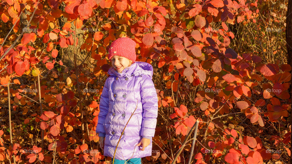 laughing child against red leaves