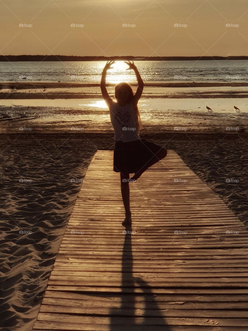 Girl in ballerina pose at sunset