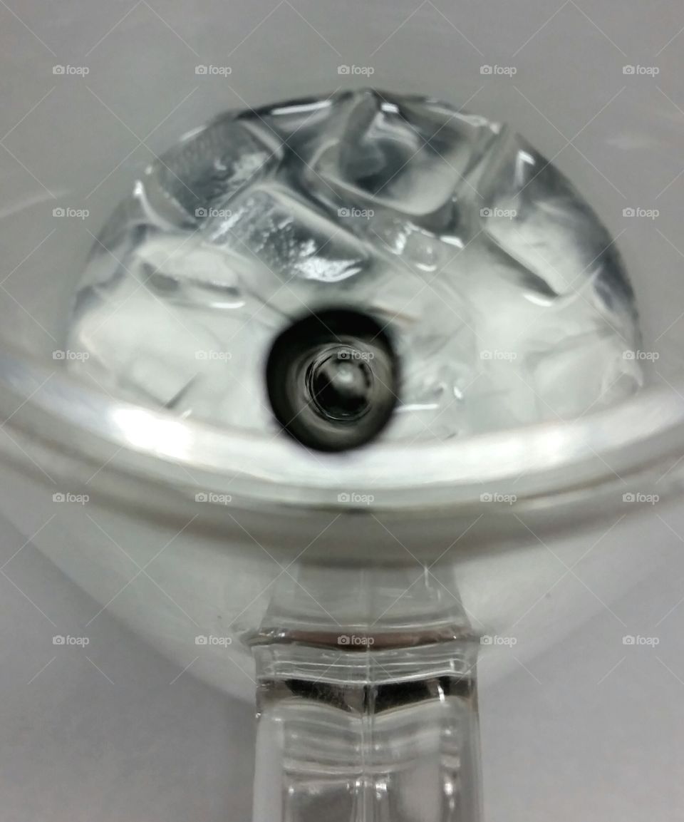 A down the straw viewpoint of a glass of ice water.