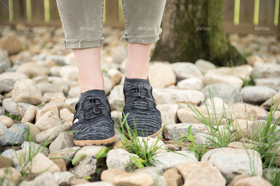 Close-up of a pair of women's shoes walking on rocks outdoors