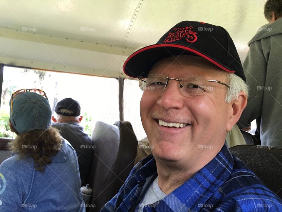 Portrait of a happy man on a bus tour through nature.