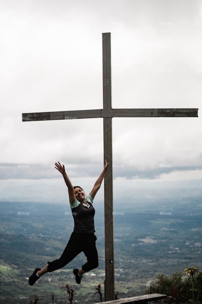 Happy girl smiling and jumping in the middle of the mountain