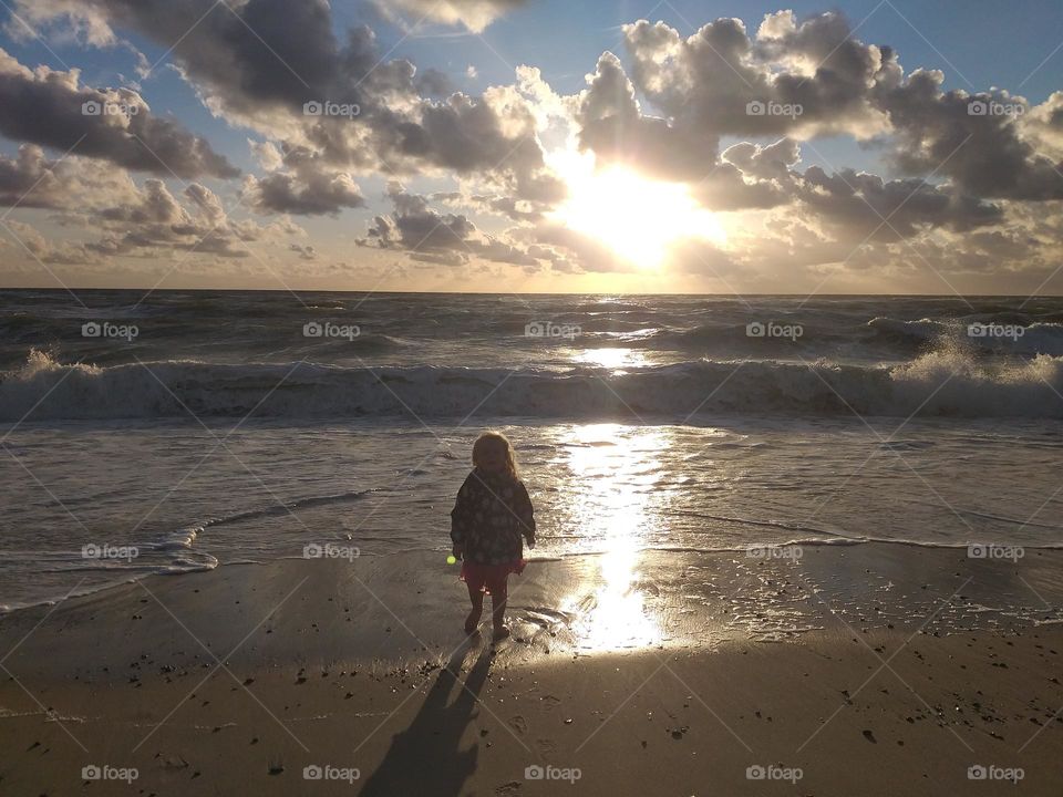 Exploring the nature. Silhouette of young girl enjoying the beach, ocean and sunset. The simple things that can bring joy to young souls.