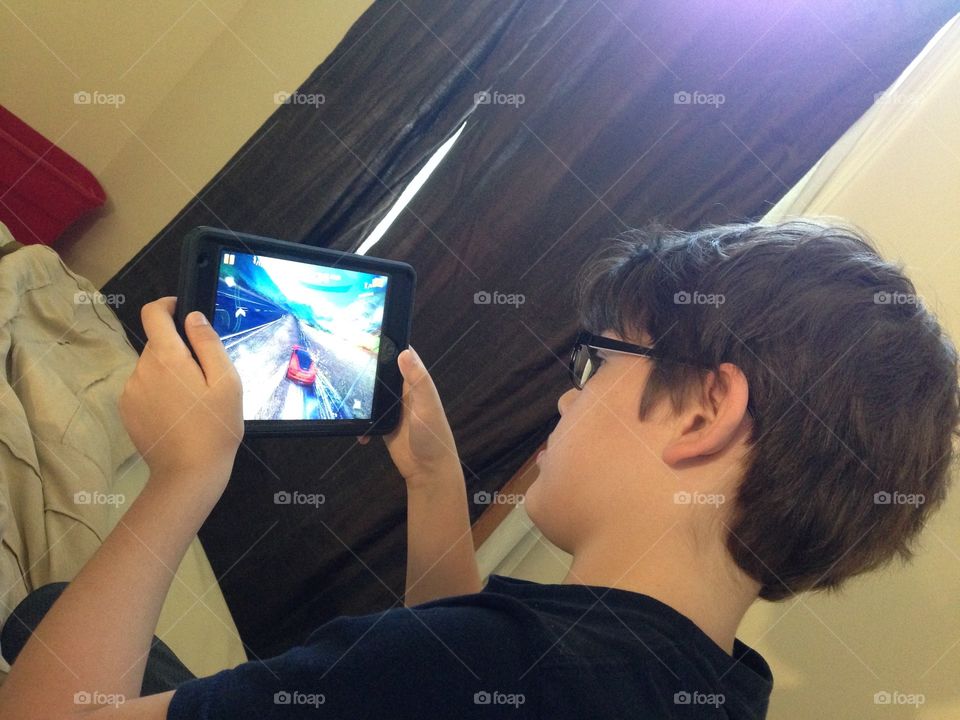 iPad with a racing game and boy playing it