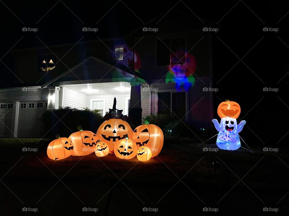 Glowing pumpkins and ghost figure. Halloween outdoor decor 