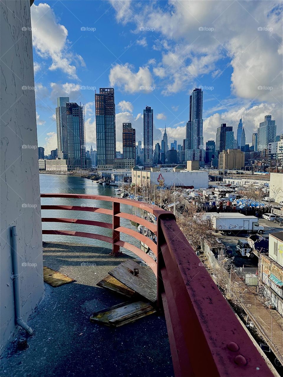 This gorgeous view unfolds from the central outpost of the “Pulaski Bridge” at “Newtown Creek” that connects LIC, Queens and “Greenpoint”, Bklyn. In the distance we see LIC and “Manhattan” incl. the “Empire State Bldg”. 2023. Hypnotic Productions