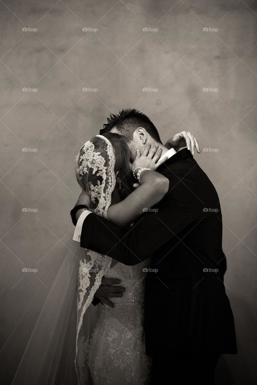 Love, photographed - Image of couple sharing an intimate first kiss on their wedding day, monochrome
