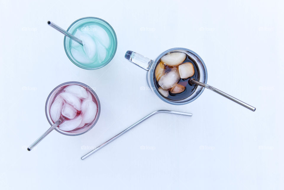 Overhead view of three drinking glasses filled with different colored liquids