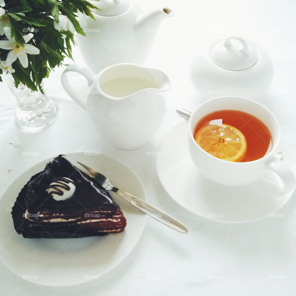 Tea time. Cup of tea with cholate cake on white background 