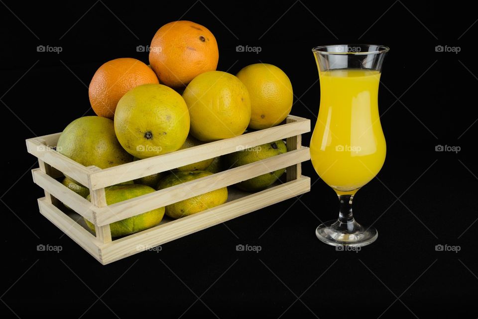 Glass with orange juice. Fruits with vitamin c with black background