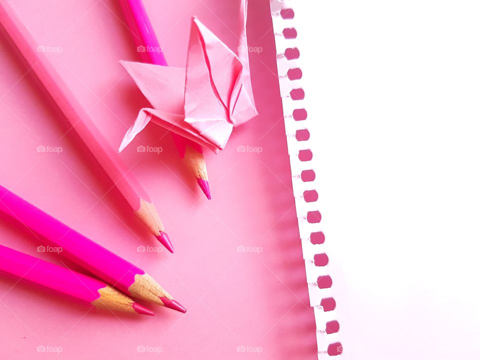 Pink origami and colored pencils