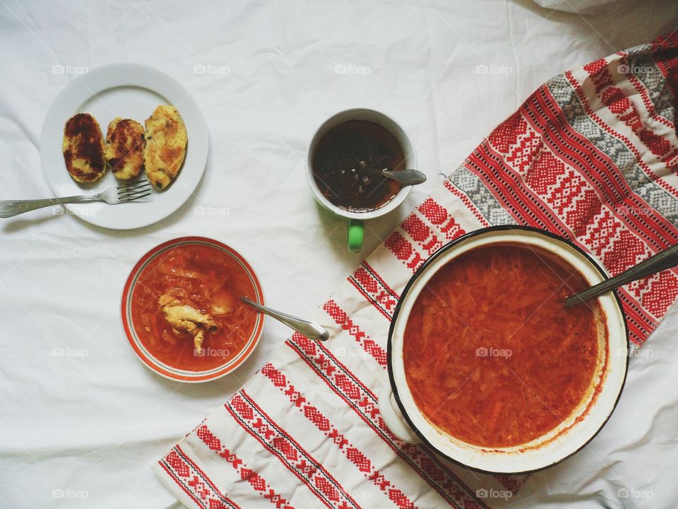 Ukrainian borscht, pies with meat and a cup of tea on the table