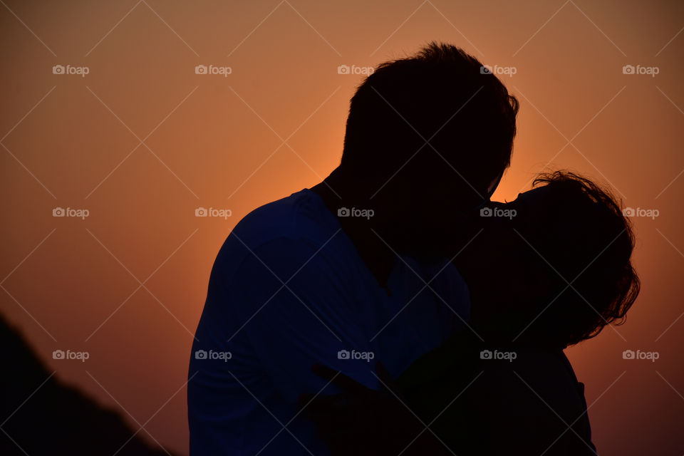 Couple kissing during a sunset