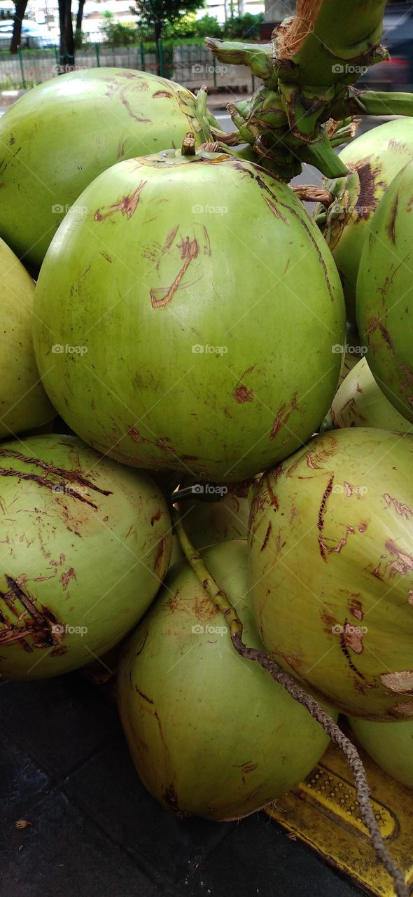 Piles of green coconuts on display.