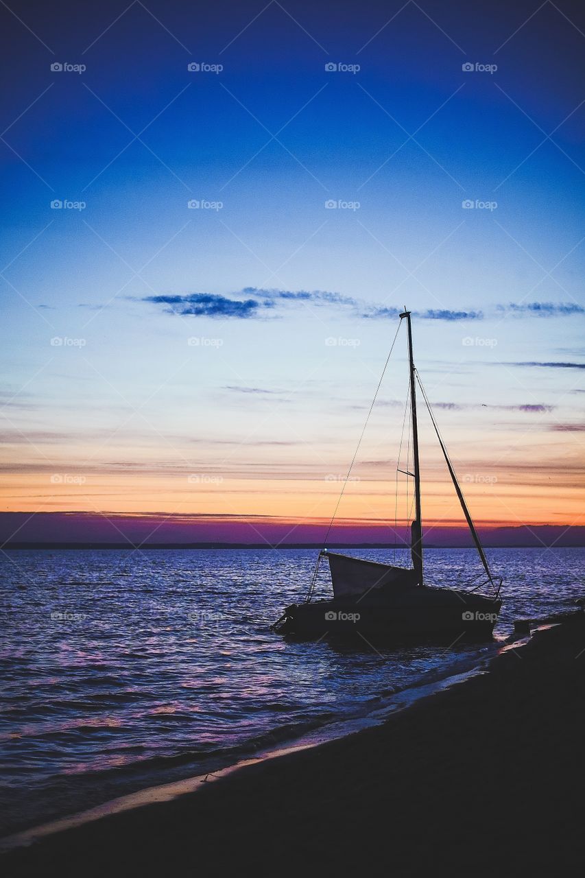 The yacht sails down the river at sunset