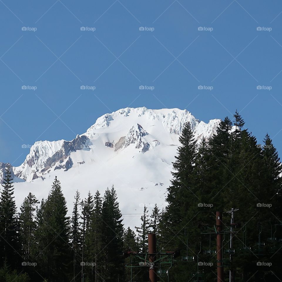 The magnificent Mt. Hood in Oregon’s Cascade Mountain Range covered in fresh springtime snow on a beautiful sunny day. 