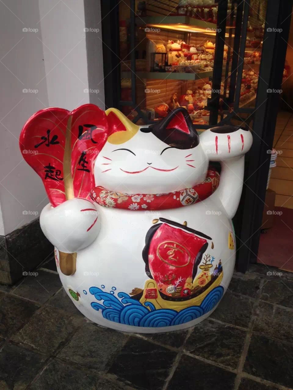 Lucky cat waving its paw at you. Isn’t that cute?