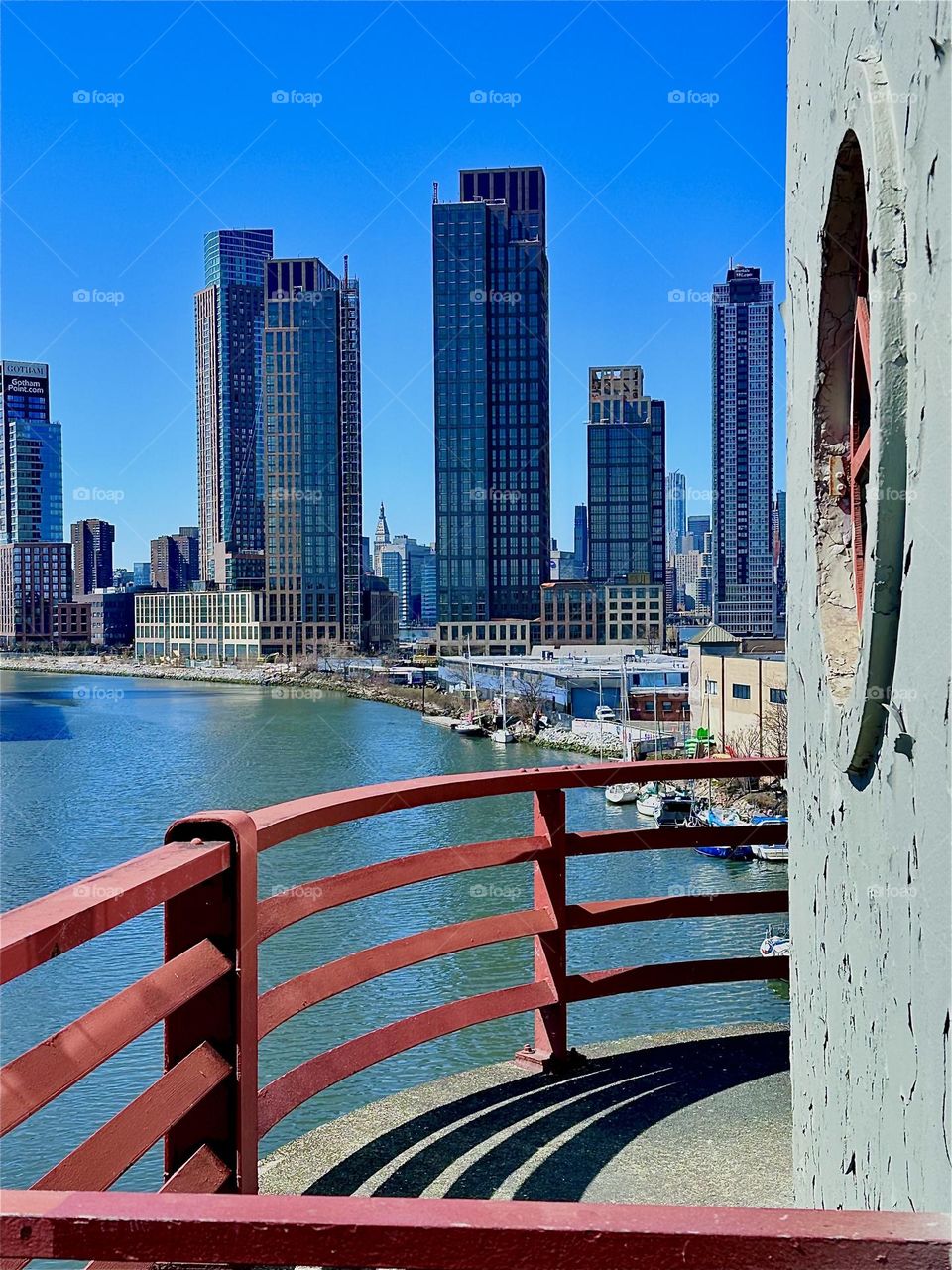 This is the central outpost of the “Pulaski Bridge” at “Newtown Creek” that connects LIC, Queens to “Greenpoint”, Brooklyn in the late afternoon sun. Behind the LIC high rises we see “Manhattan”. 2024. Hypnotic Productions